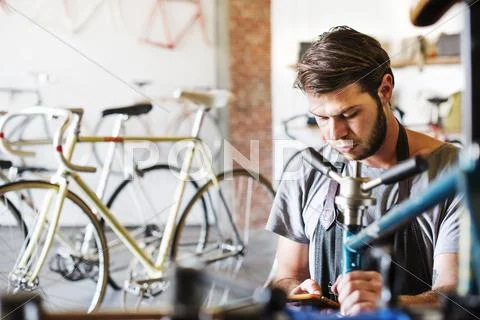 A man working in a bicycle repair shop. Stock Photos
