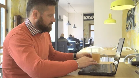 Man working, browsing laptop computer, drink beer, profile, cafe, steadicam 動画素材 73266389