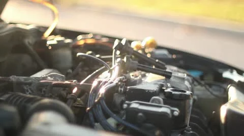 Man working on car installing spark plugs cu at sunset Stock Footage 17910177