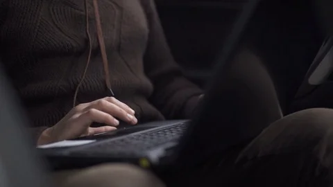 A man is working in a car typing text on a laptop Stock Footage 81518920