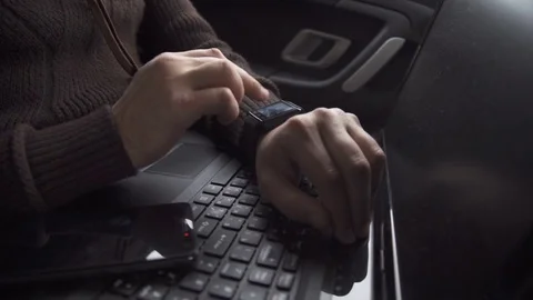A man is working in a car. Uses smart watches Stock Footage 82348500