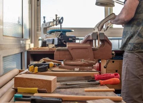 Man working in a carpentry workshop and crafting a wooden model Stock Photos