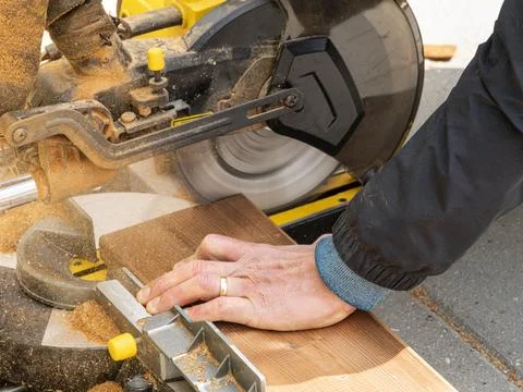 Man working with circular blade saw for cutting wood beam. Stock Photos