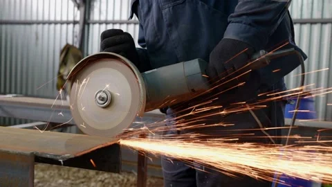 A man is working with a circular saw. Sparks fly from the hot metal. The man was 스톡 동영상 166077977