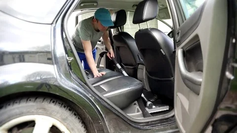 Man working on client car with vacuum cleaner Stock Footage 69084370