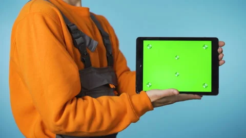 Man in working clothes showing green screen tablet from below Stock Footage 144317380