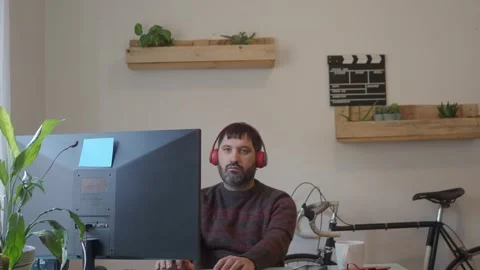 Man working with a computer and headphones in an office or at home Stock Footage 147547835