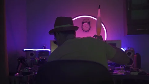 Man working on computer and smoking hookah in neon light. Stock Footage 130043079