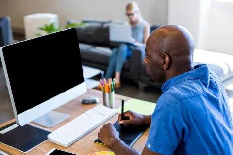 Man working on computer and using pen tablet Foto stock