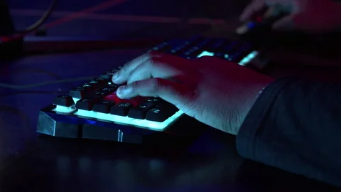 A man working at a computer, close-up of hands and neon glowing keyboard Stock Footage 152799991
