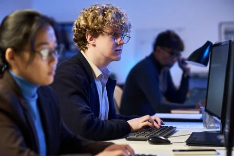 Man Working on Computer with Colleagues in Cybersecurity Office Stock Photos