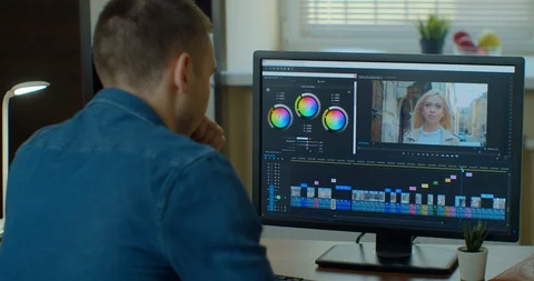 Man working on computer Color Correction Post Production video or photo in Видео 129453159