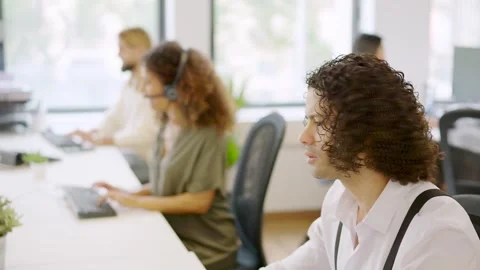 Man working with computer in a coworking next to colleagues Video stock 258219823