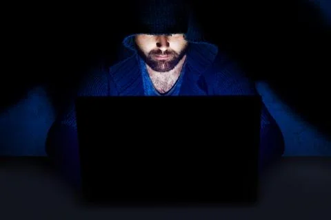 Man working at computer in dark room Stock Photos