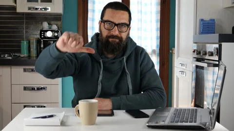 Man working on computer doing thumb down sign with hand looking at the camera. Video stock 152426346