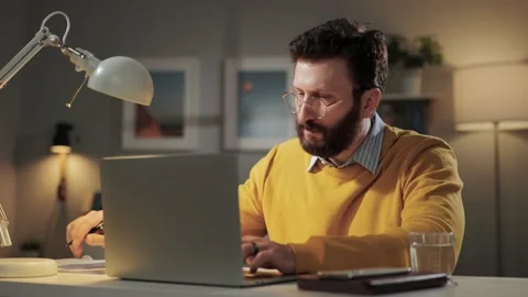 Man working at computer. Focused bearded man in glasses working at computer in Видео 170473166