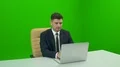 The man working with a computer on the green background 4k or 4k+ Resolution