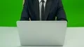 The man working with a computer on the green background 4k or 4k+ Resolution