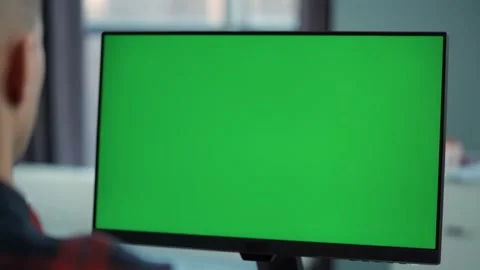 Man Working At Computer With Green  Mock Up Screen Sitting At Desk in Office Stock-Footage 229317653