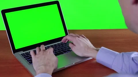 A Man Working At A Computer With A Green Screen Видео 49669302