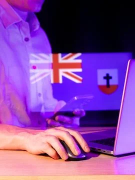 Man working on computer with holographic display of two national flags Stock Photos