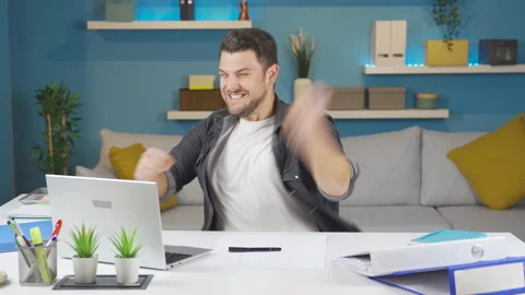 The man working from the computer at home screams with joy when things go well. 스톡 동영상 233043835