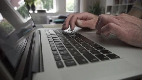 Man working on a computer with living room in the background Stock Footage 139444759