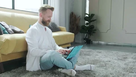 Man working at the computer with a lot of reminder notes, sitting near sofa. Stock Footage 155651671