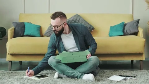Man working at the computer with a lot of reminder notes, sitting near sofa. Stock Footage 168530297