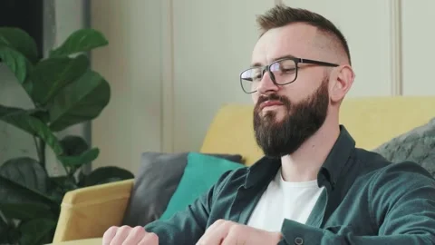 Man working at the computer with a lot of reminder notes, sitting near sofa. Stock Footage 168976269