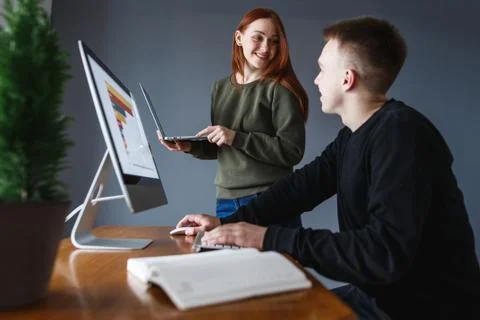 The man is working at the computer. A man is smiling at a colleague on work. Stock Photos