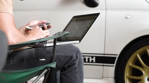 Man working on a computer near the car. close-up Stock Footage 204878680