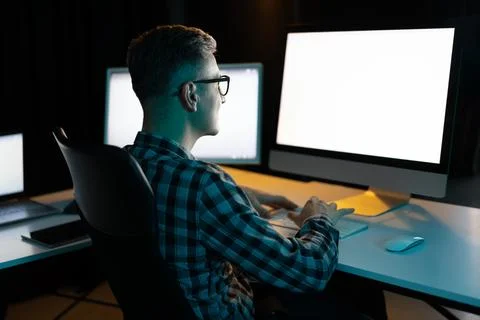 Man Working On Computer At Night In Office Foto stock
