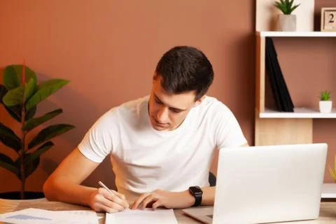 Man working at the computer in the office and filling documents Stock Photos