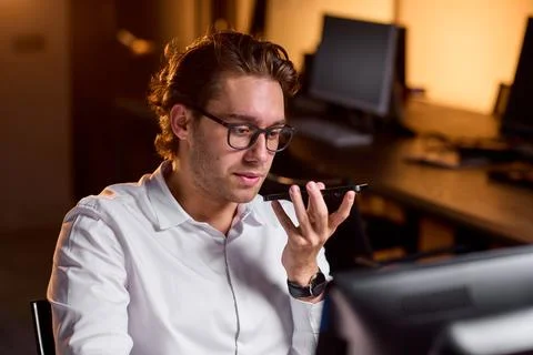 Man working on computer in office environment with concentrated side view, white Stockfoto's
