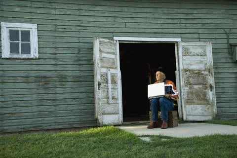 Man Working On Computer Outside Of Barn Or Shed Stock Photos