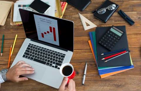 Man working on computer presentation sitting at unusual handcrafted rough wooden Stock Photos