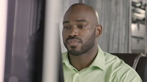 Man working at computer, smiling, amused, close up shot Stock Footage 61952994