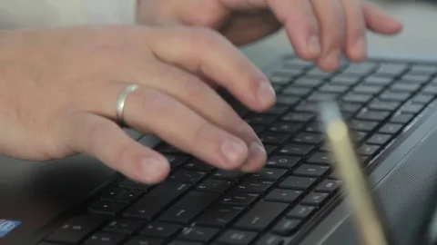 Man working at a computer, typing on the keyboard. In the frame of the hand Stock Footage 71028865