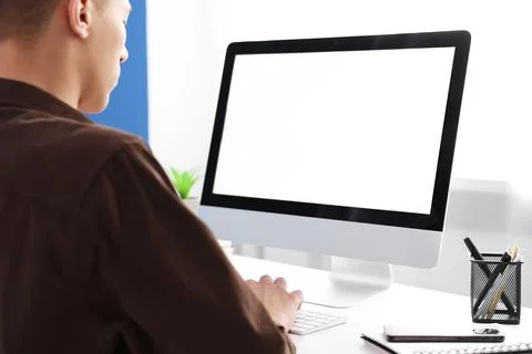 Man working on computer at white desk in office, closeup. Mockup for design Stock Photos