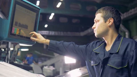 Man working with computerized machine operating with factory line at inductrial Stock Footage 88805984