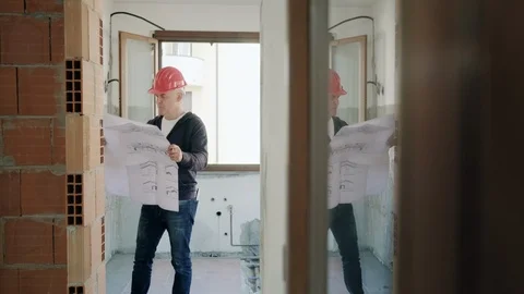Man Working In Construction Site Looking At New House Blueprints Stock Footage 118130125
