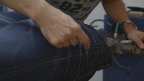 Man working on denim jeans in workshop Stock Footage 114712013