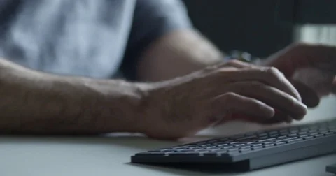 Man working on a desk and typing on a flat modern keyboard 動画素材 76052724