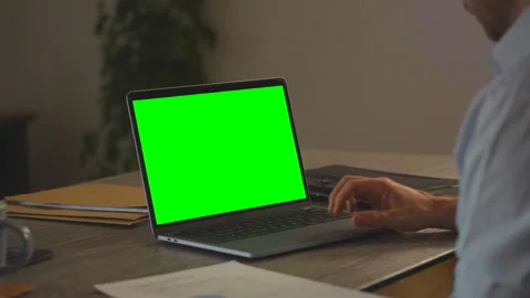 Man Working at Desk with Green Screen Laptop Over Shoulder Stock Footage 336503235