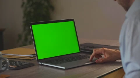 Man Working at Desk with Green Screen Laptop Over Shoulder Stock Footage 336975770