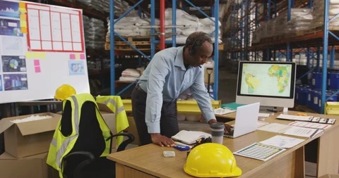Man working at a desk in a warehouse 4k Stock Footage 113386800