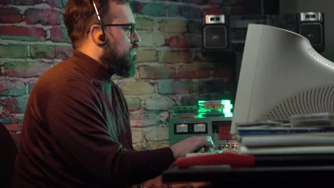Man Working on Desktop Computer From 1980's Listening Music With Headphones on Stock Footage 306056981