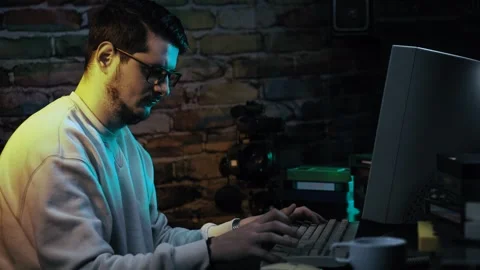 Man Working on Desktop Computer From 1990's Surrounded With VHS Video Cassette 스톡 동영상 302443908