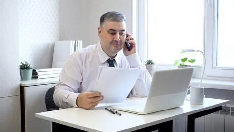 Man Working with Documents and Talking on Phone in Office Stock Photos